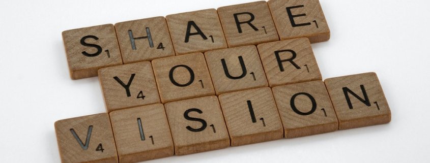 Scrabble game tiles spell out the words "Share Your Vision"