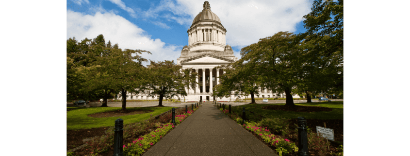 The Capitol Building in Olympia is pictured with trees on either side.